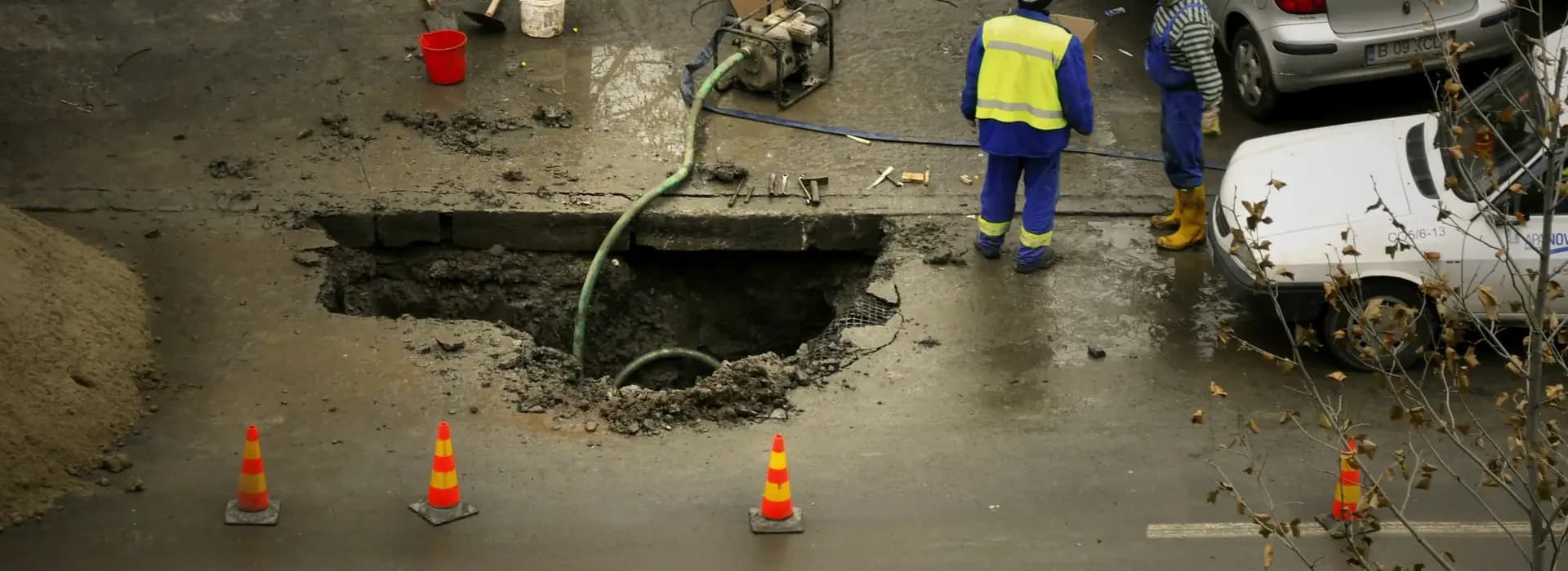 Aerial view of a crew in high-visibility clothing at a road excavation